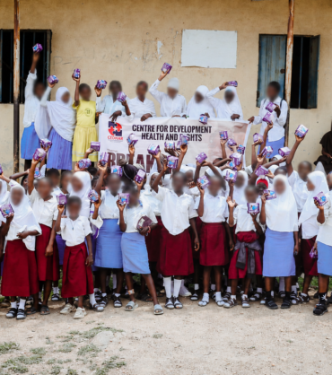 Group photo celebrating menstrual dignity as students receive and hold their reusable pads.